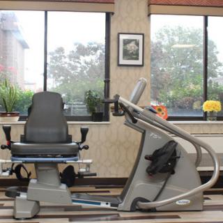 An indoor gym with exercise equipment and a view through large windows.