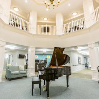 An elegant lobby featuring a grand piano, surrounded by a spacious and stylish design.
