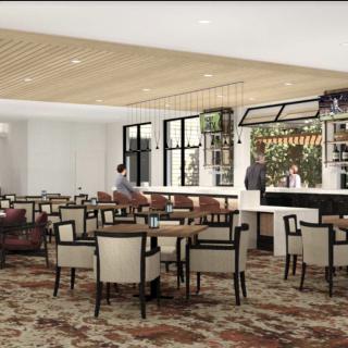 A modern restaurant interior with elegant dining tables and a bar.