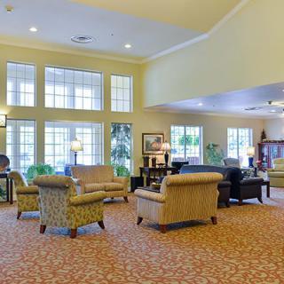 A spacious and well-lit living room with comfortable seating and large windows.
