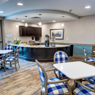 A modern cafeteria with blue checkered chairs and a well-lit dining area.