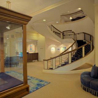 A modern lobby featuring a curved staircase and elegant decor.