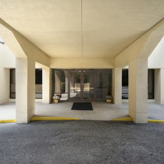 A view of the entrance to a building, showcasing its architectural design with columns and a welcoming lobby area.