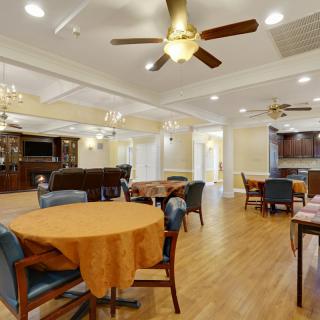 A cozy dining area with tables, chairs, and ceiling fans.
