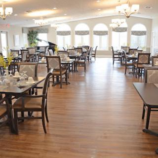 A spacious and elegantly designed dining area featuring wooden floors and well-arranged tables.
