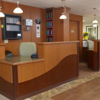 A modern and inviting office reception area with wooden desks and shelving.