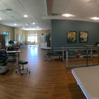 A spacious rehabilitation therapy room equipped with exercise equipment and a bright, inviting atmosphere.
