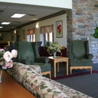 A cozy lounge area with armchairs, a coffee table, and floral arrangements.