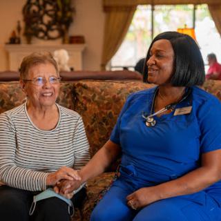 A warm moment of connection between a caregiver and an elderly resident, showcasing compassion and care.