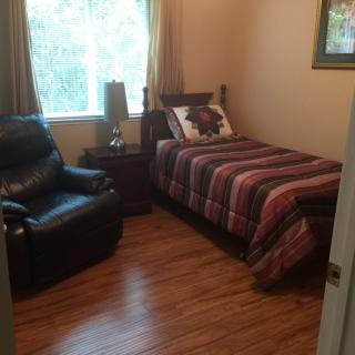 Cozy bedroom with a single bed and armchair.