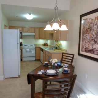 A cozy kitchen and dining area with a well-set table and warm lighting.