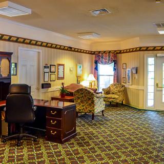 A well-furnished office lobby with a desk, seating area, and decorative elements.