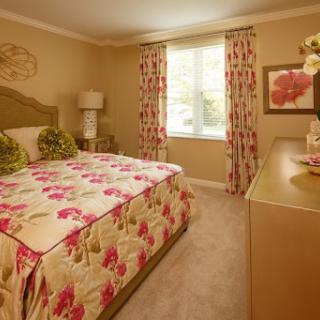 A beautifully decorated bedroom featuring floral patterns and warm tones.