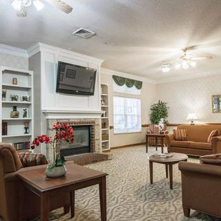 A cozy living room with a fireplace, comfortable sofas, and a mounted television.
