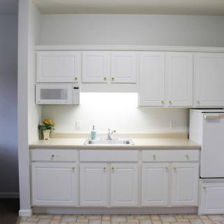 Modern kitchen with white cabinets and appliances.