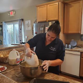 A person mixing ingredients in a bowl in a cozy kitchen.