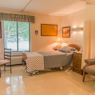 A cozy and simple bedroom setup with natural light filtering through the window.