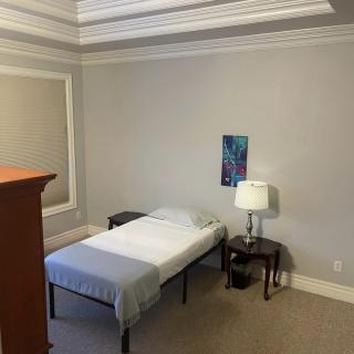 A minimalist bedroom with a single bed and simple decor.