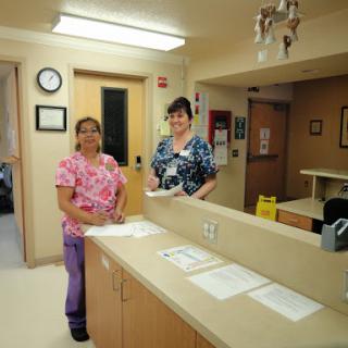 Two healthcare professionals in a hospital reception area.