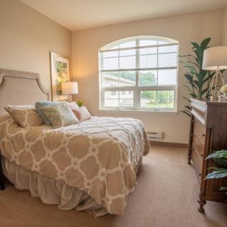 Cozy bedroom with a large window and elegant decor.