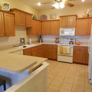 A cozy kitchen featuring wooden cabinets, a tiled floor, and modern appliances.