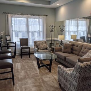 A cozy and modern living room featuring a comfortable sofa, stylish chairs, and a glass coffee table.