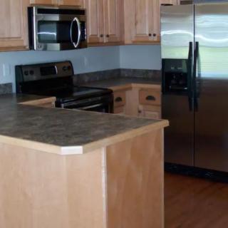 A modern kitchen with wooden cabinets and stainless steel appliances.
