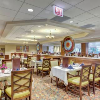 A well-lit dining area in a restaurant with neatly arranged tables and chairs.