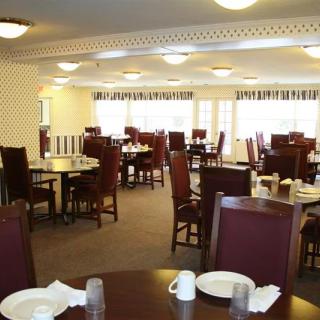 An empty dining room with neatly arranged tables and chairs, set for service.