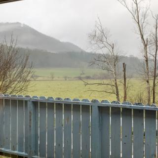 A serene countryside view featuring rolling hills and misty clouds.