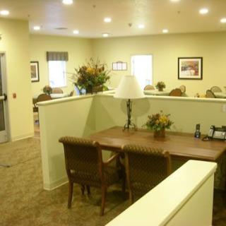 A well-lit office interior with a desk, chairs, and decorative elements.