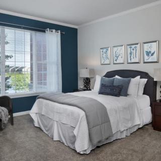 A modern bedroom with stylish decor and a large window.