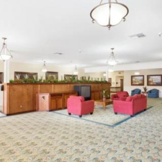 A spacious lobby with red seating, wooden cabinets, and decorative lighting.