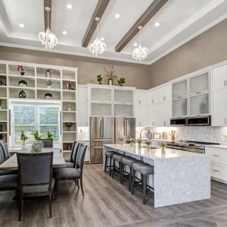 A modern kitchen with an elegant dining area, featuring open shelving and marble countertops.