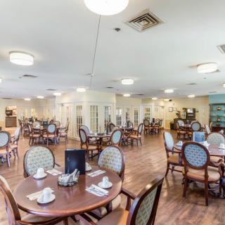 A spacious and well-lit dining area with neatly arranged tables and chairs.