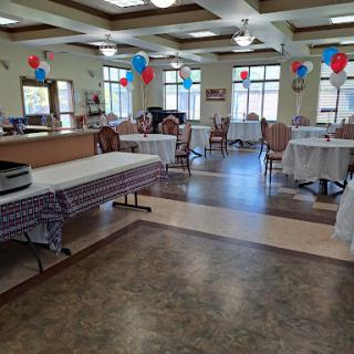 A spacious dining area decorated with balloons, ready for a gathering or celebration.