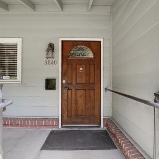 Front entrance of a house with a wooden door and a welcome mat.