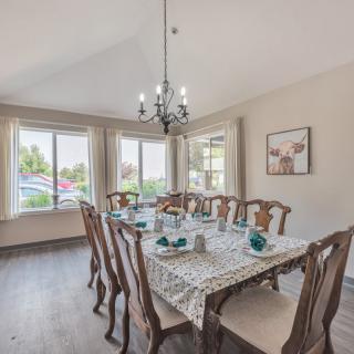 A well-decorated dining room with a long wooden table and elegant chandelier.