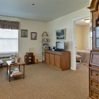 A cozy living room with a television and wooden furniture.