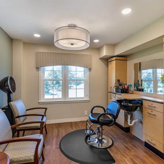 A cozy hair salon interior with styling station and comfortable seating.