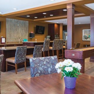 A cozy dining area with a bar, featuring comfortable seating and floral decorations.