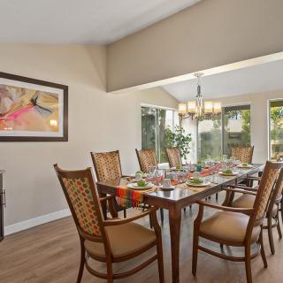 A well-decorated dining room with a set table and elegant chandelier.