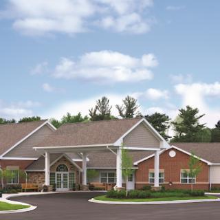 Front view of a modern community facility surrounded by trees and blue skies.