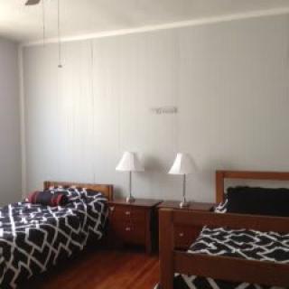 A neatly arranged bedroom with two twin beds and matching nightstands.