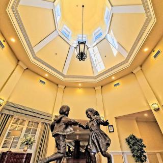 Interior view featuring a sculpture of children dancing under a dome ceiling with elegant lighting.