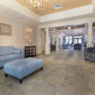 A spacious and elegantly decorated lobby area with comfortable seating and a chandelier.