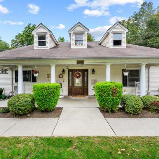 A charming suburban house with a welcoming front porch and well-maintained landscaping.