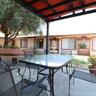 A cozy outdoor seating area featuring a table and chairs, surrounded by a charming courtyard.