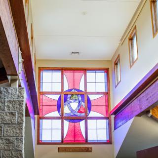 A beautifully designed stained glass window illuminating the interior space with vibrant colors.