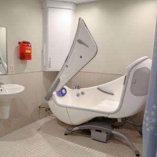 A modern, accessible bathtub in a healthcare facility bathroom.